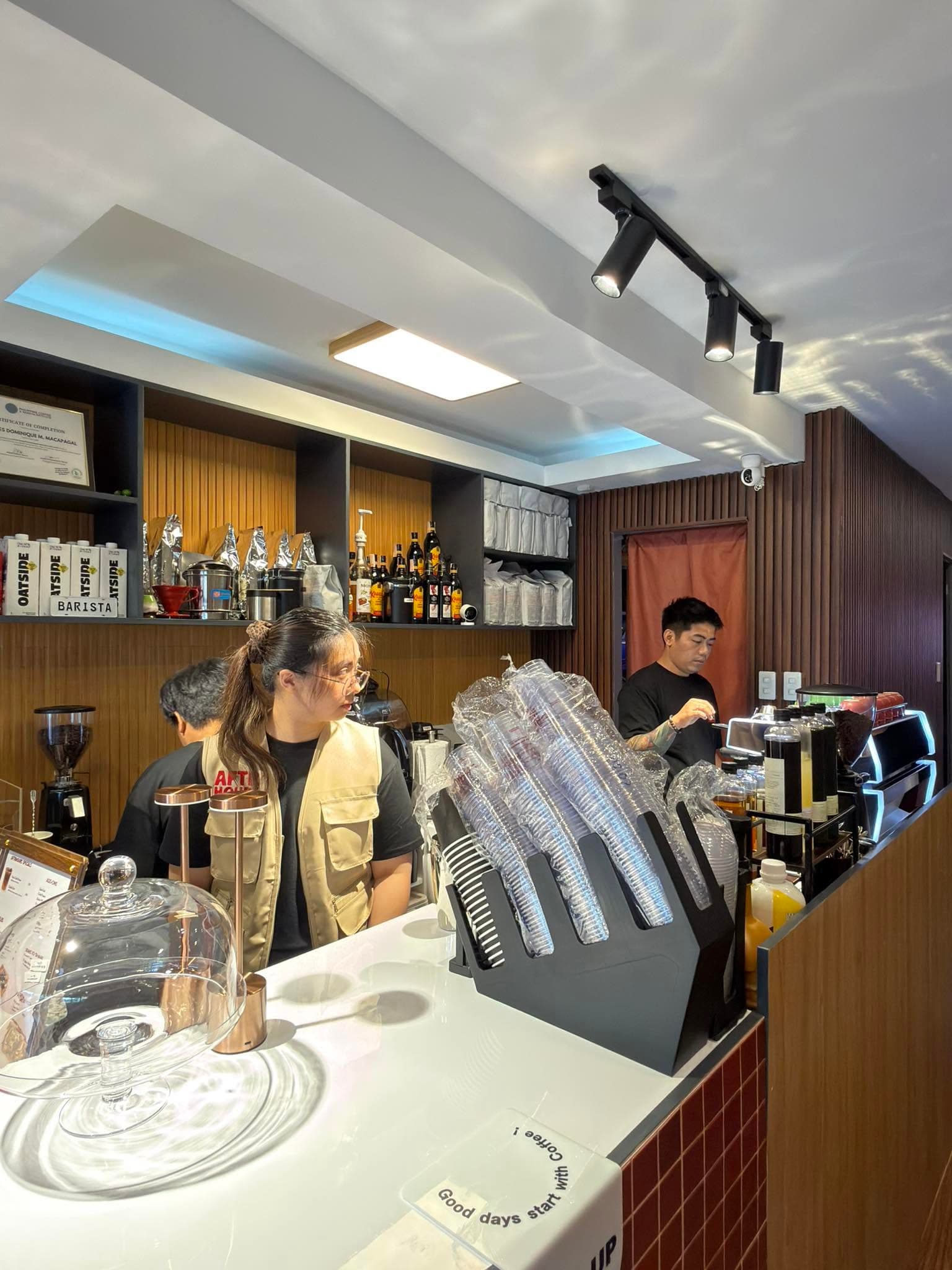 Aftrhours Cafe barista counter with menu boards and drink preparation.